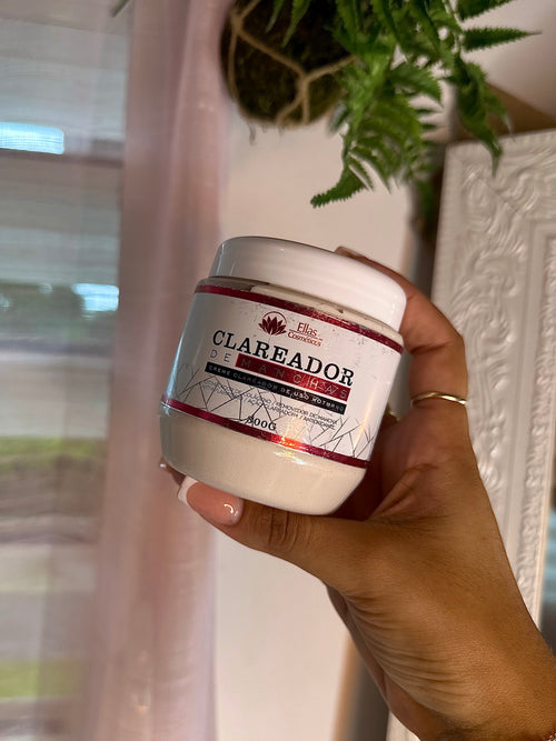 Pot blanc de crème Clareador visage et corps, tenu à la main